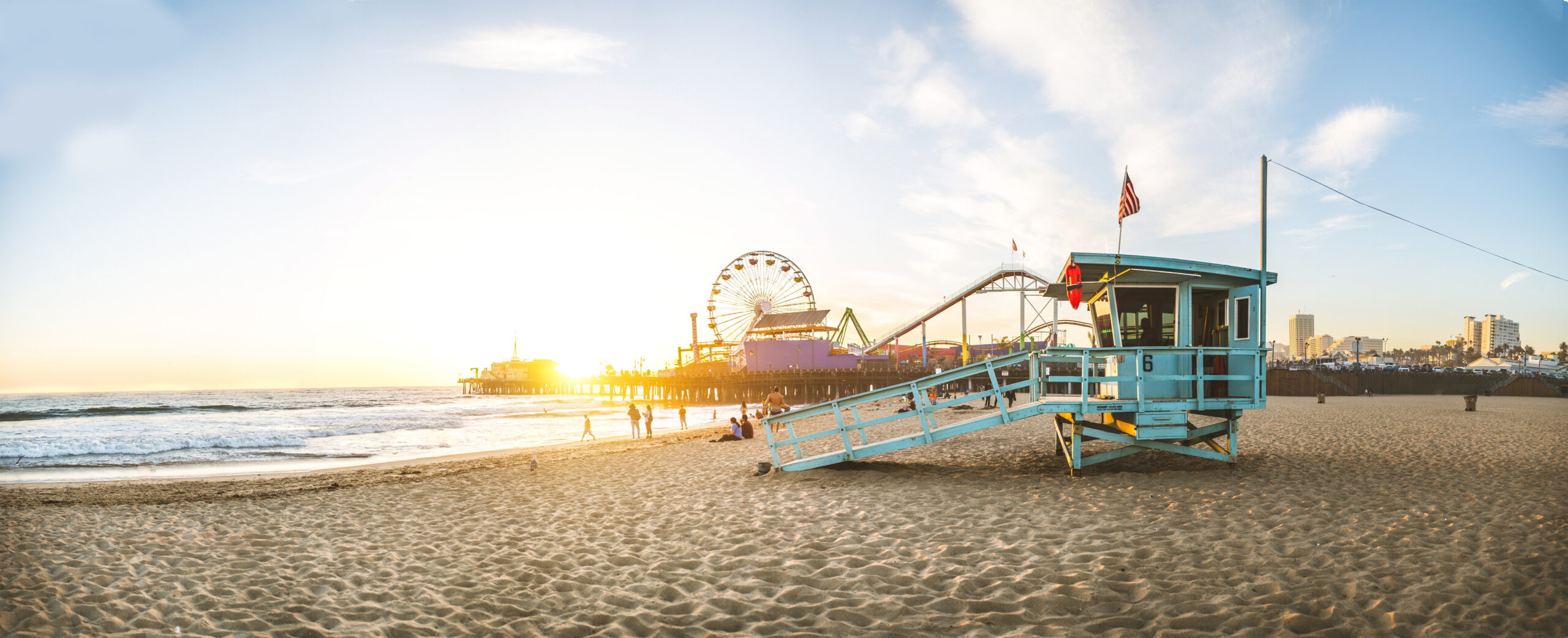 Sunset at Santa Monica pier. A lifeguard station on the beach is in the foreground with the Santa Monica pier set behind.