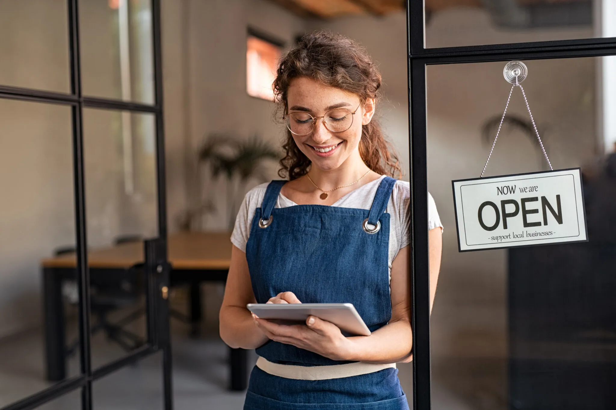 A Georgia small business owner reviewing documents on a laptop while preparing to file the Georgia annual report for a new business in 2025.