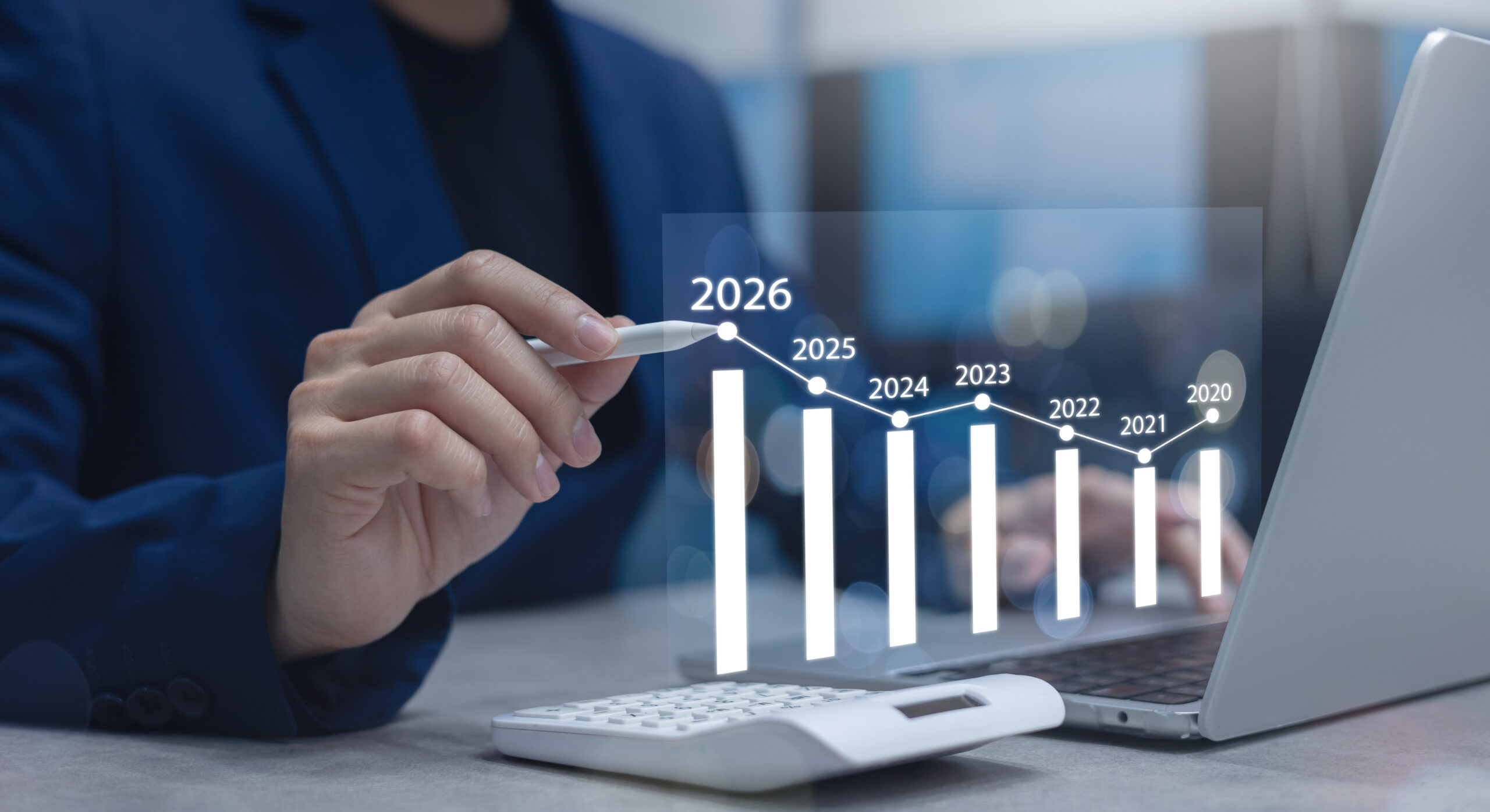 Business owner reviewing 2026 annual report fee changes by state on a laptop with compliance documents and notes on desk